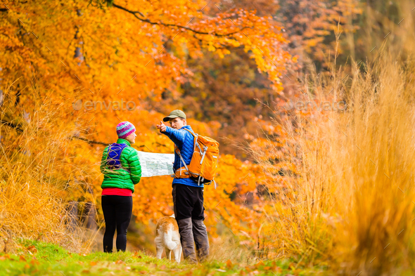 Couple hiking with map in autumn forest - Stock Photo - Images
