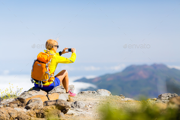 Woman hiker taking photos in mountains - Stock Photo - Images