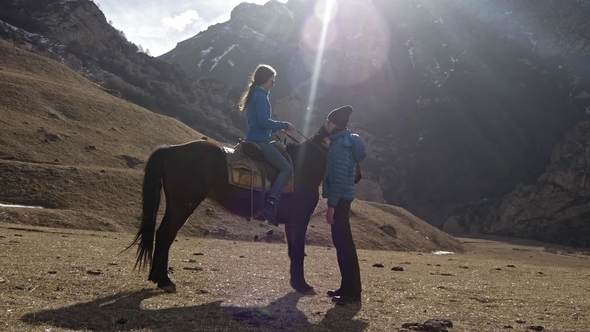 Guy with a Girl and a Horse in the Mountains