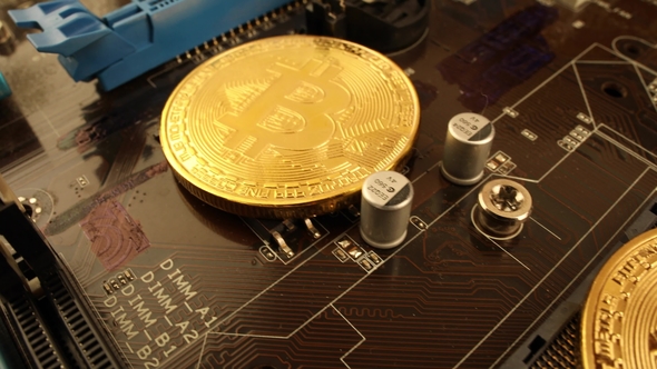 Gold Bit Coin BTC Coins on the Motherboard. Bitcoin Is a Worldwide Cryptocurrency alt