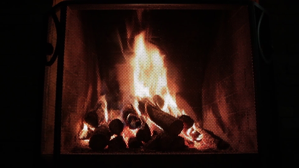 Fireplace with Christmas Decorations. The Firewood Is Burning in the Fireplace.