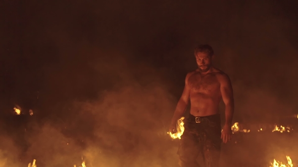 Strong Free Fighter Walks Between Bonfires in the Field alt