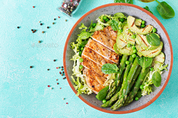 Chicken fillet cooked on a grill with a garnish of asparagus and grilled avokado. - Stock Photo - Images