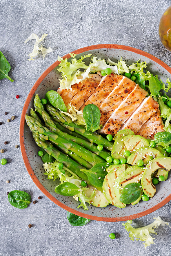 Chicken fillet cooked on a grill with a garnish of asparagus and grilled avokado. - Stock Photo - Images