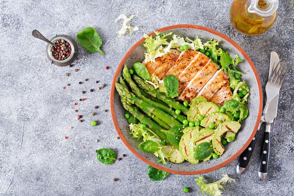 Chicken fillet cooked on a grill with a garnish of asparagus and grilled avokado. - Stock Photo - Images