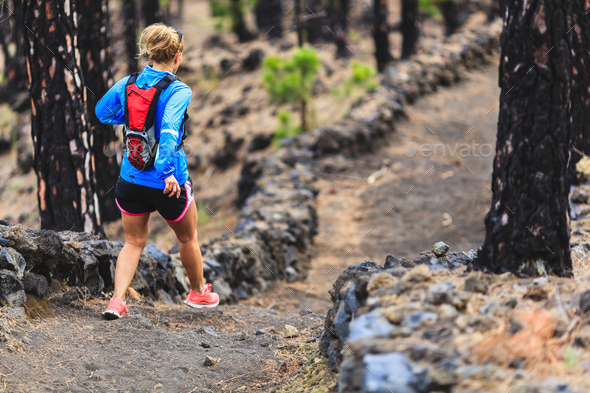 Young woman trail running in forest - Stock Photo - Images