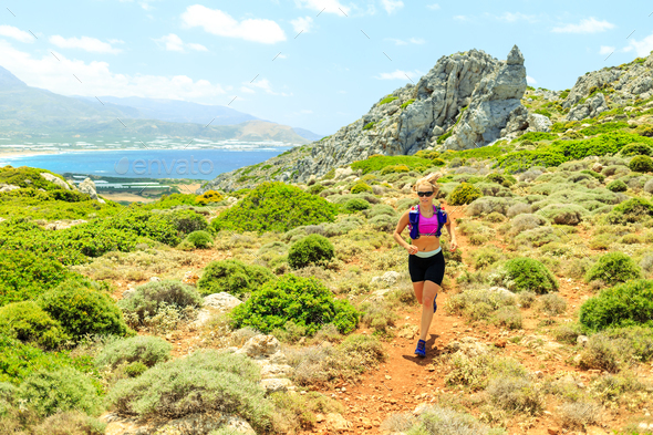 Happy woman trail running in beautiful mountains Stock Photo by blas