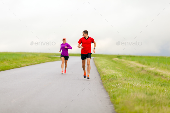 Couple running on country road - Stock Photo - Images