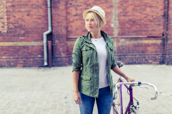 Hipster woman with vintage road bike in city