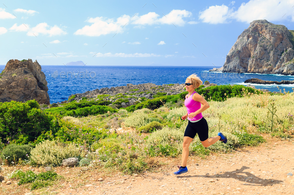 Happy woman trail running in beautiful mountains - Stock Photo - Images