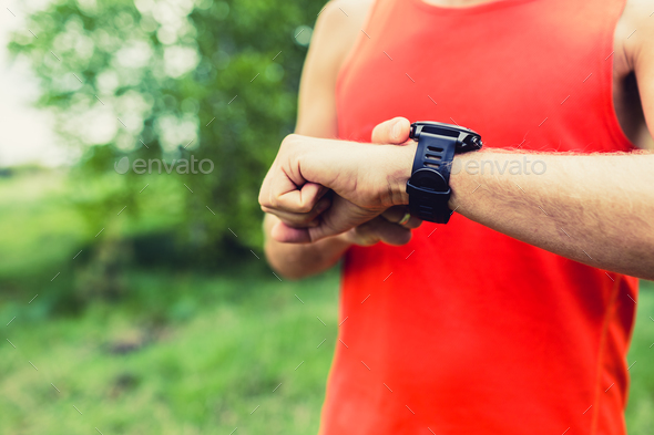 Man running and checking sport smart watch - Stock Photo - Images
