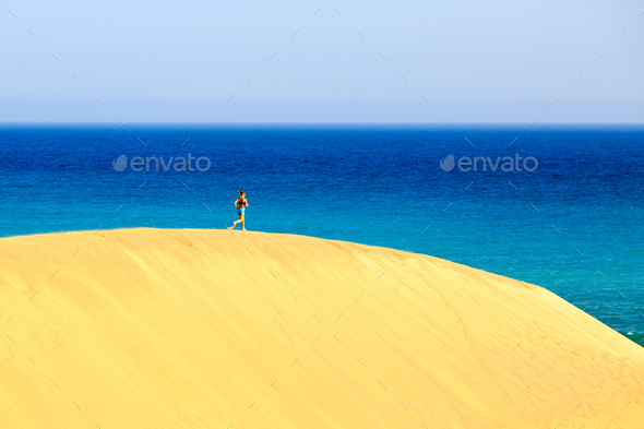 Young woman running on sand desert dunes - Stock Photo - Images