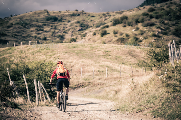 Mountain bike rider on country road, track trail in inspirationa - Stock Photo - Images