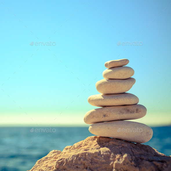 Stones balance at the beach, stack over blue sea - Stock Photo - Images