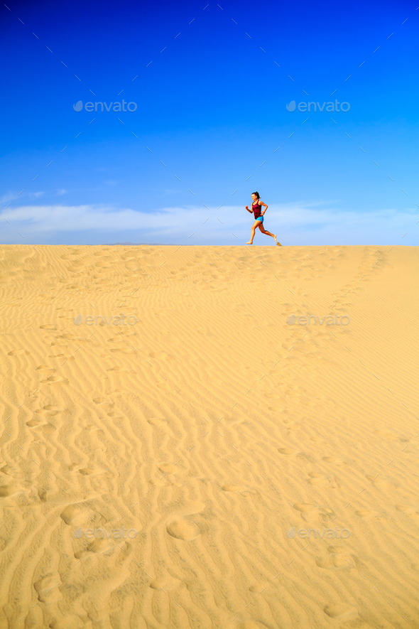Young woman running on sand desert dunes - Stock Photo - Images