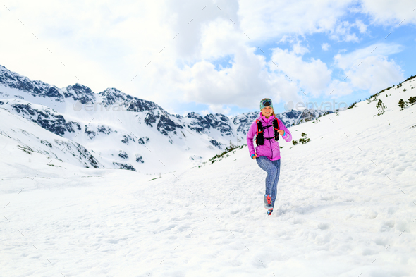 Woman running in mountains in inspirational winter landscape - Stock Photo - Images