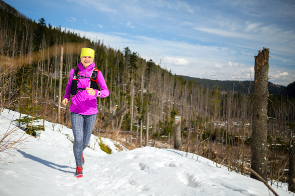 Woman winter trail running in mountains on snow - Stock Photo - Images