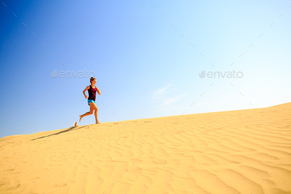 Young woman running on sand desert dunes - Stock Photo - Images