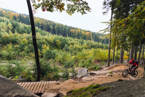 Mountain biker riding cycling in autumn forest - Stock Photo - Images