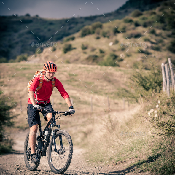 Mountain bike rider on country road, track trail in inspirationa - Stock Photo - Images