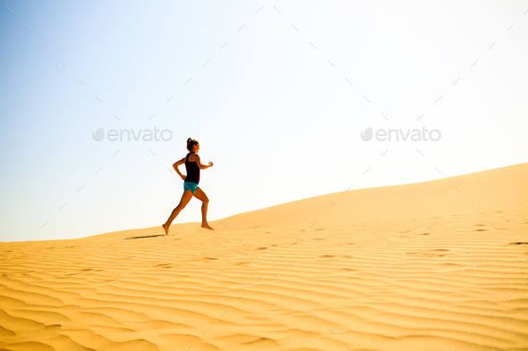 Young woman running on sand desert dunes - Stock Photo - Images