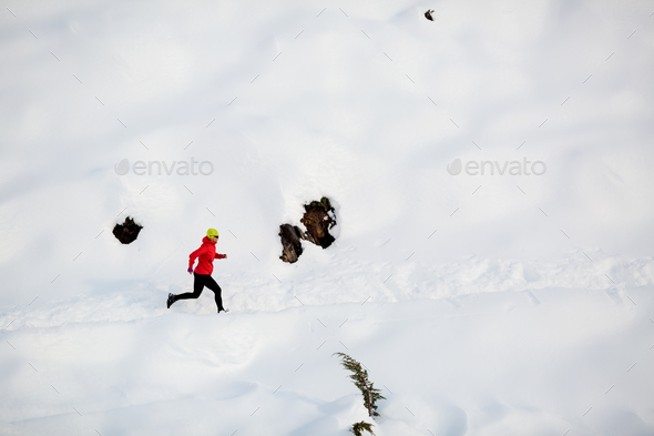 Woman running in winter mountains - Stock Photo - Images