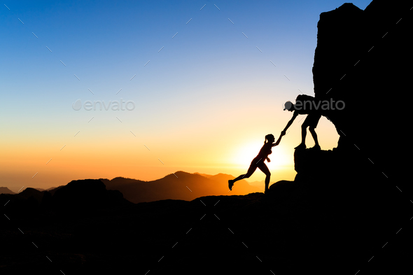 Teamwork couple climbing helping hand - Stock Photo - Images