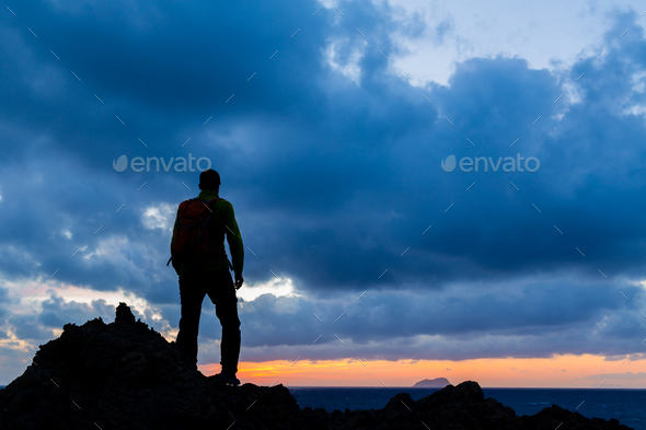 Hiking silhouette backpacker, inspirational sunset landscape - Stock Photo - Images