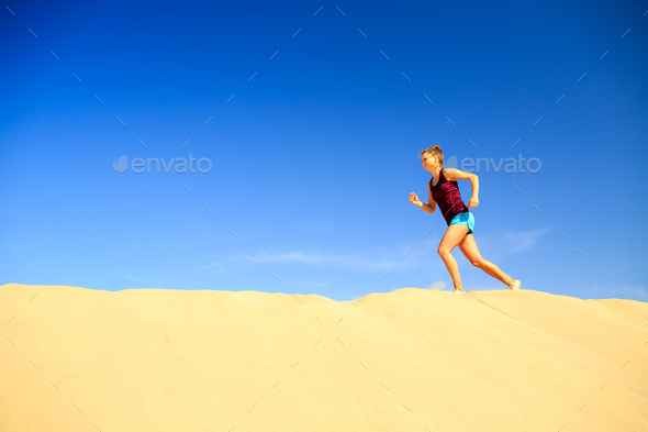 Young woman running on sand desert dunes - Stock Photo - Images