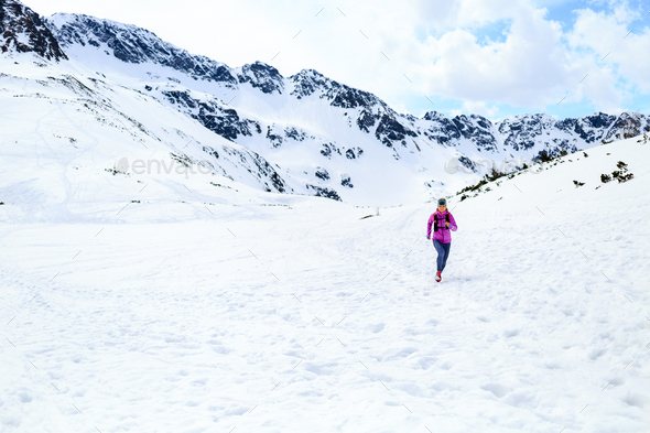 Happy woman running in mountains on winter sunny day - Stock Photo - Images