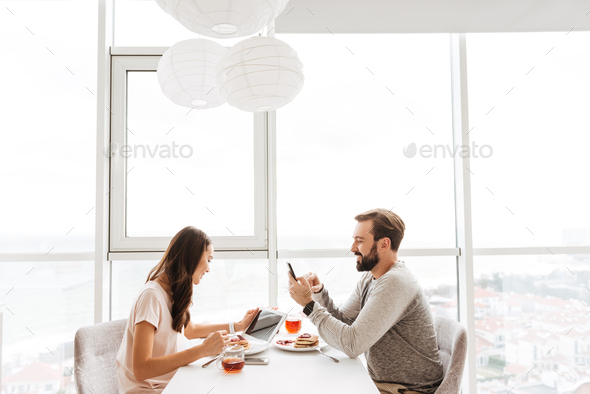 Happy young couple having breakfast - Stock Photo - Images