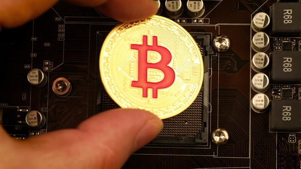 Gold Bit Coin BTC Coins on the Motherboard. Bitcoin Is a Worldwide Cryptocurrency alt