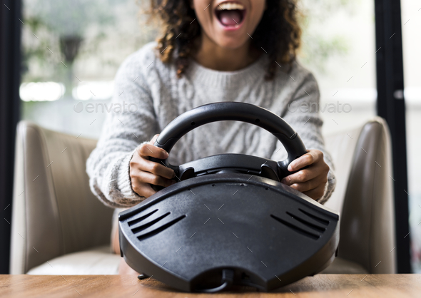 Woman playing a car racing vdo game - Stock Photo - Images