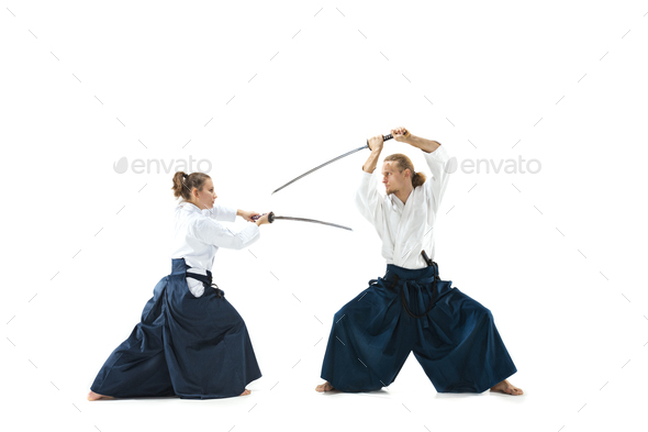 Man and woman fighting and training aikido on white studio background - Stock Photo - Images