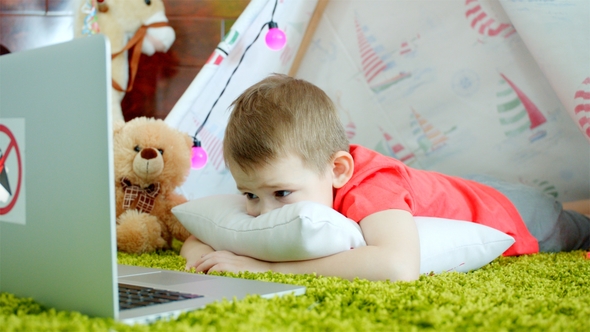 Little Boy Is Watching Cartoons in the Playroom