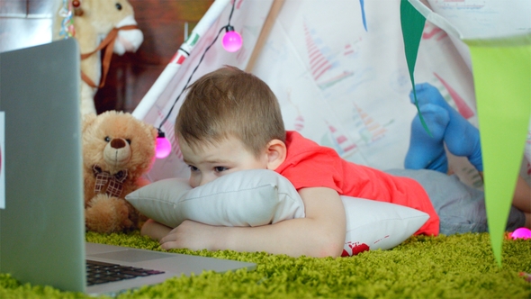 Little Boy Is Watching Cartoons in the Playroom alt