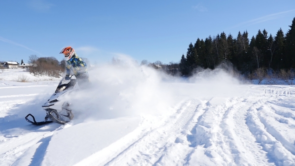 A Person Turns Over a Snowmobile