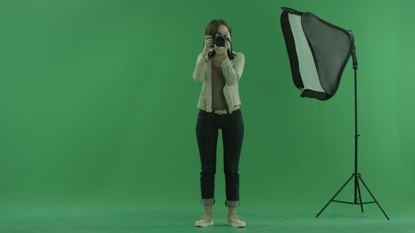 A Young Woman Is Taking Some Photos of the Viewer on the Green Screen
