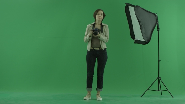 A Young Woman Tries To Take Some Photos of the Viwer on the Green Screen