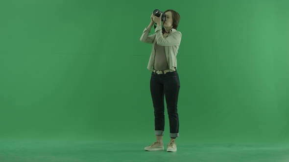 A Young Woman Is Taking Photos Upper Herself on the Left Hand Side on the Green Screen