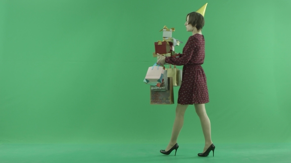 A Young Woman Is Going From Right Side with a Lot of Gifts on the Green Screen