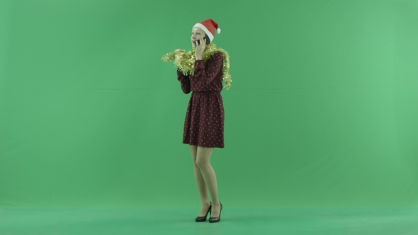 A Young Christmas Woman Is Calling By Phone on the Green Screen