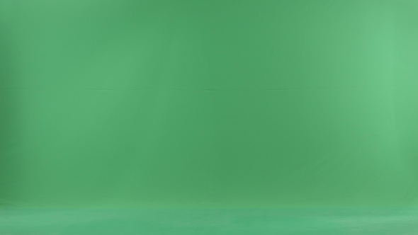 A Young Christmas Woman Is Going From the Left Side and Talking on Her Phone on the Green Screen