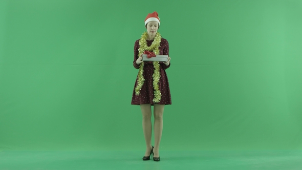 A Yong Woman Is Opening an Empty Christmas Gift on the Green Screen