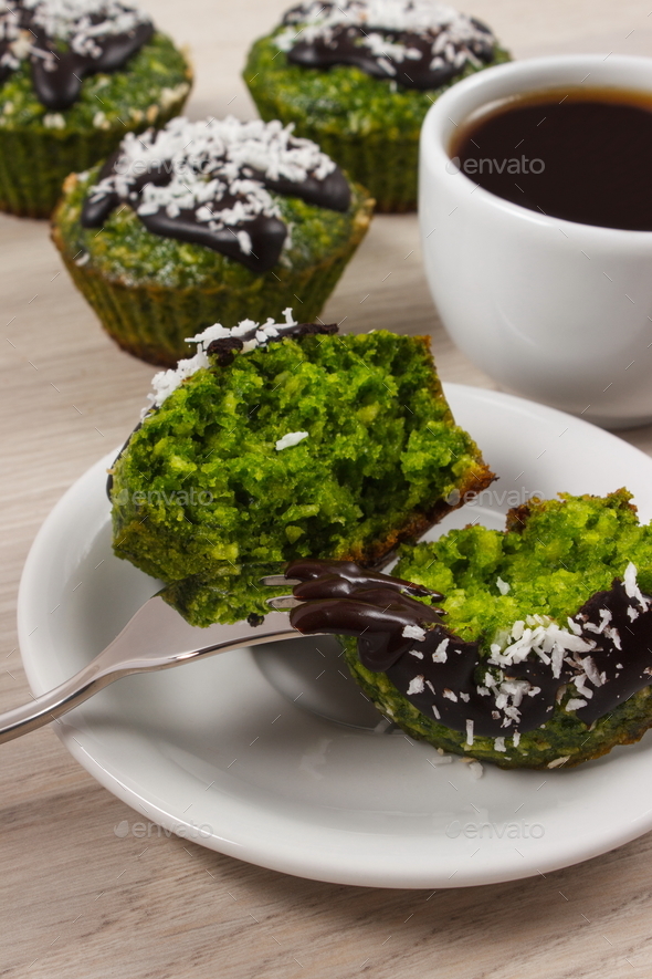 Fresh muffins with spinach, desiccated coconut, chocolate glaze and cup of coffee - Stock Photo - Images