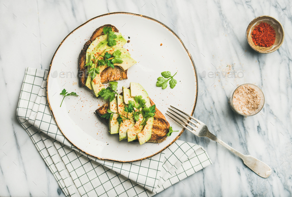 Flat-lay of avocado toast on plate and seasoning , top view - Stock Photo - Images