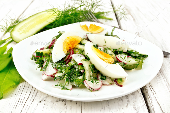 Salad with radish and egg in plate on light board - Stock Photo - Images