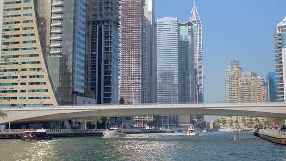 Yachts and Pleasure Boats Are Floating in Dubai in Sunny Weather, Modern Bridge
