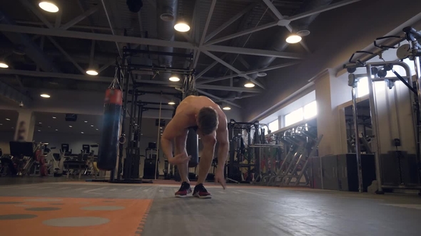 Handsome Man in Fitness Club Interior. Muscular Man Posing and Looking Incamera alt
