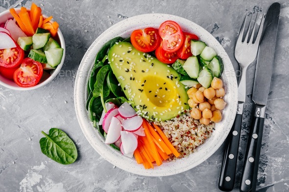 buddha bowl with quinoa, spinach, avocado, cucumbers, tomatoes, carrots, radishes, chickpeas - Stock Photo - Images